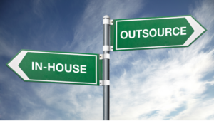 Street sign displays two different directional paths - in-house vs. outsourcing.