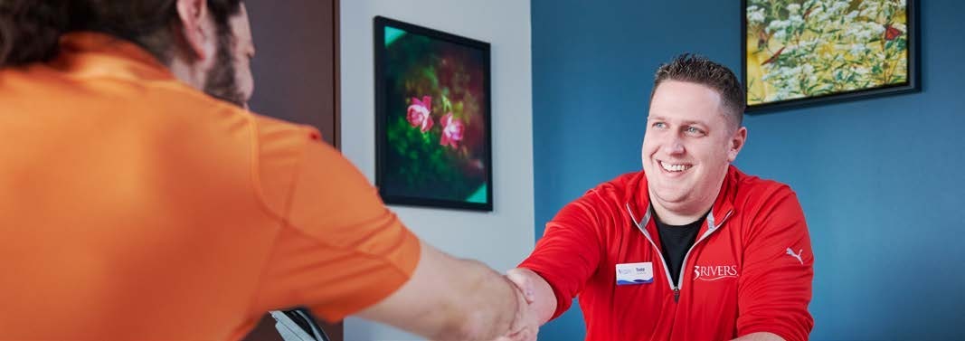 A 3Rivers employee greeting a member with a handshake.