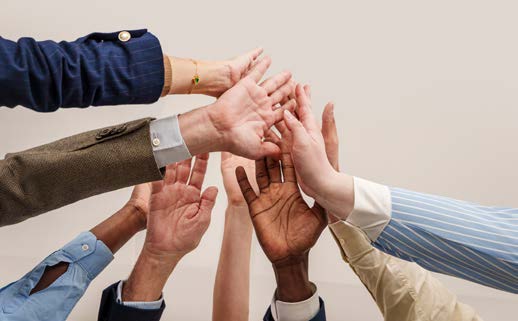 Colleagues joining hands in a team high-five.