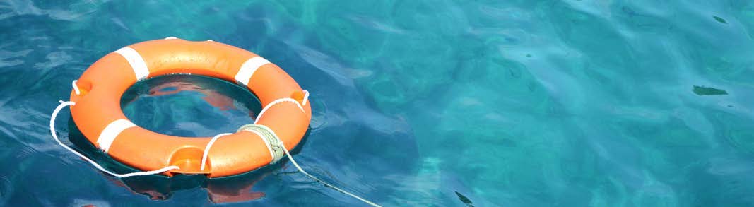 An orange life ring floating in blue water.